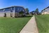 Charming suburban apartment buildings with well-maintained lawns and a clear blue sky.