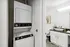 Sleek in-unit laundry setup adjacent to a modern bathroom with elegant decor.