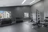 Modern apartment gym with weightlifting equipment, benches, and natural light.