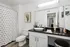Modern bathroom with sleek countertop, stylish decor, and bright lighting.