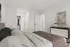 Cozy bedroom interior with a plush bed, modern dresser, and a sliding closet door.