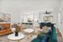 Elegant apartment interior featuring an open-concept living room with orange couch, stylish white kitchen, and modern dining set.