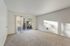 Inviting living room with plush carpeting and sliding glass doors leading to a private balcony.