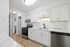 Bright modern kitchen with sleek white cabinets, stainless steel appliances, and marble countertops.