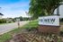 Signage for Renew Durham apartment community amidst lush greenery and well-kept landscaping.