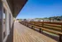 Spacious wooden deck offering panoramic views of surrounding modern apartment complex and lush greenery.