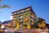 Stylish urban apartment building with vibrant green exterior and modern design elements at dusk.