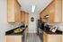 Modern kitchen with sleek black countertops, light wood cabinets, and stainless steel appliances.