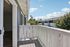 Inviting balcony with white railing overlooking a peaceful residential area under a clear blue sky.