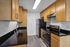Modern kitchen featuring sleek wooden cabinets, granite countertops, and stainless steel appliances.