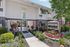 Inviting entrance to a modern apartment complex surrounded by lush landscaping and vibrant greenery.