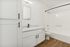 Modern bathroom with a white vanity, granite countertop, and wooden flooring, offering a clean and elegant design.