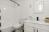 Sleek and modern bathroom with white fixtures, polished countertop, and tasteful decor.