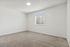 Inviting empty room with plush carpet, white walls, and a large window featuring blinds.