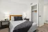 Inviting bedroom with a wooden headboard, plush bedding, and modern side lamps.