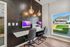 Chic office nook with dual workstations, stylish pendant lighting, and a large window with a view.
