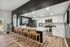Modern kitchen with sleek white cabinets, stainless steel appliances, and a chic island with bar seating.