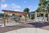 Inviting outdoor area featuring pergolas, grills, seating, and a play structure in a community setting.