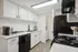 Contemporary kitchen with white cabinets, black appliances, and a stylish countertop.