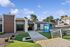 Stylish apartment complex entrance with modern architecture, fresh landscaping, and a bright, inviting leasing office sign.