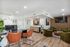 Stylish office interior with modern decor featuring leather chairs, green velvet seating, and contemporary artwork.