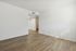 Bright, empty room with wood flooring and white walls, highlighting space and natural light.