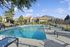 Inviting outdoor pool area with lounge chairs and mountain views framed by lush greenery.