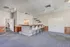 Bright open area featuring a sleek bar with high chairs, modern ceiling lights, and wooden accents.