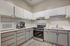 Modern kitchen with white cabinetry, stainless steel appliances, and sleek countertops.