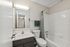 Stylish bathroom with modern fixtures, a sleek vanity, and white tiled shower area.