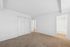 Bright, empty room with fresh carpet and built-in closet.