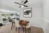 Chic dining room with a wooden table and plush chairs, opening to a stylish living area with modern decor.