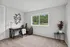 Bright home office with modern desk, ergonomic chair, decorative wall art, and large window view.