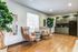 Chic living area with elegant chairs, large potted plants, and a kitchenette with sleek gray cabinets.