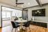 Inviting dining space featuring a round marble table with chic black chairs, modern decor, and wall-mounted TV in a brightly lit room.