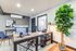 Contemporary home office with sleek desk, modern decor, large indoor plant, and natural light.