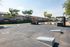 Inviting outdoor community area with picnic tables, barbecue grill, and playground surrounded by residential buildings.