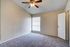 Inviting bedroom with plush carpeting, soft lighting, and a ceiling fan for ultimate comfort.