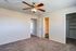 Inviting bedroom featuring soft carpet, a modern ceiling fan, and ample closet space.