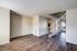 Spacious open-plan living area with modern wooden floors and a sleek staircase in a duplex apartment.