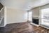 Bright living room with hardwood floors, a fireplace, and large windows with blinds.