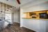 Stylish apartment interior with open-concept kitchen and sleek staircase.