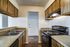 Stylish kitchen with modern black appliances, dual sink, and wood cabinetry.
