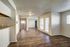 Open and airy living room with hardwood floors and natural light pouring through large windows.