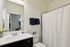 Chic bathroom featuring a modern sink, elegant mirror, and plush navy towels.