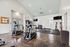 Bright, modern gym with exercise equipment including ellipticals, weights, and a flat-screen TV.