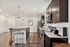 Modern kitchen with dark cabinets, granite countertops, and stainless steel appliances.