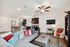 Bright open-concept living area featuring a cozy sofa with colorful cushions, modern kitchen, and stylish decor.
