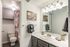 Contemporary bathroom with sleek vanity, large mirror, and elegant lighting.