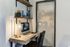 Compact home office corner with a wooden desk, modern computer setup, and stylish lighting.